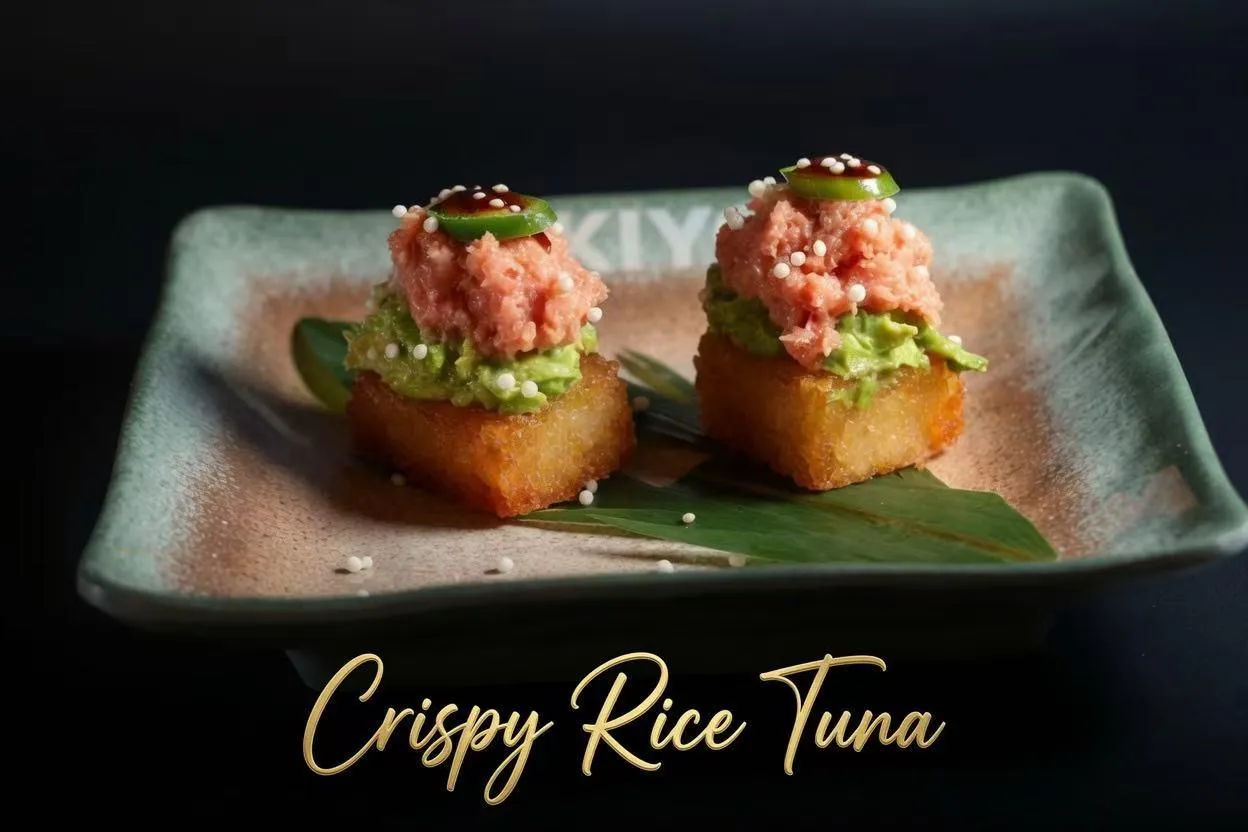 Two crispy rice tuna bites layered with avocado, raw tuna, jalapeño and tobiko on bamboo leaf square plate at Akiyo, a Japanese Restaurant in Johnson City
