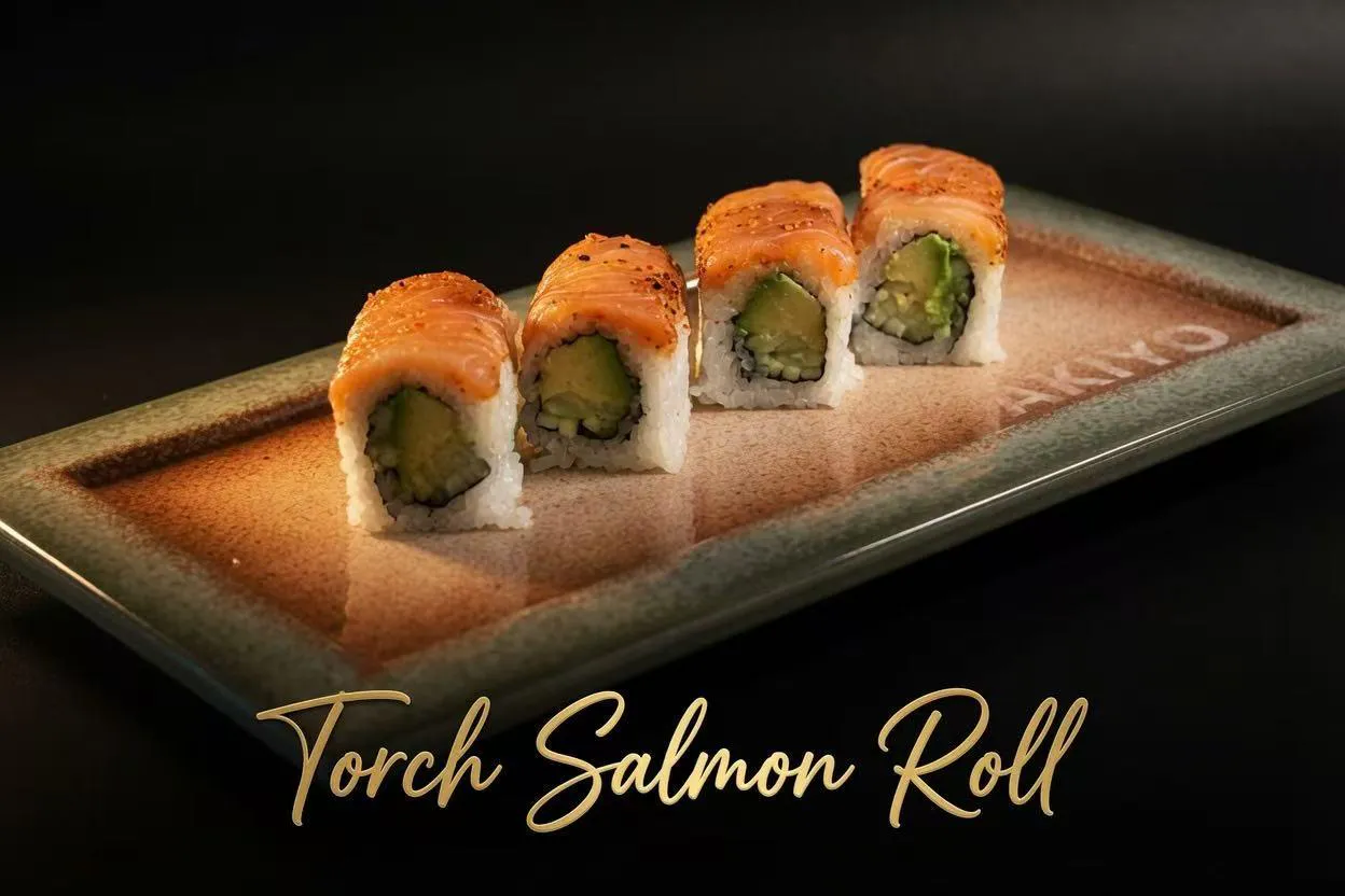 Four torch salmon sushi roll pieces topped with seared salmon and avocado filling on textured brown-green plate at Akiyo, a Japanese Restaurant in Johnson City